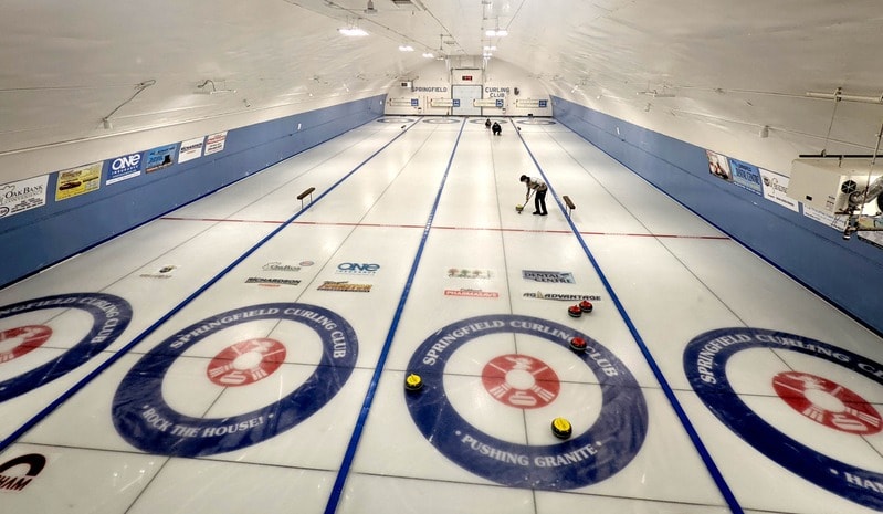 Members of a curling club enjoying time together at an indoor rink